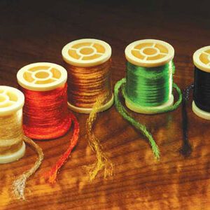 A wooden table with six spools of thread on it.