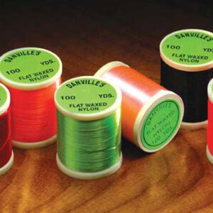 A group of different colored spools of thread.