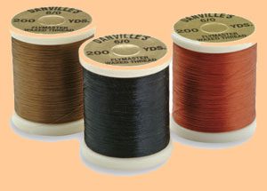 A group of three spools of thread in different colors.