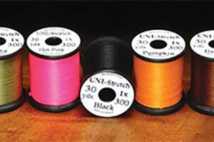 A group of three spools of thread on top of a table.