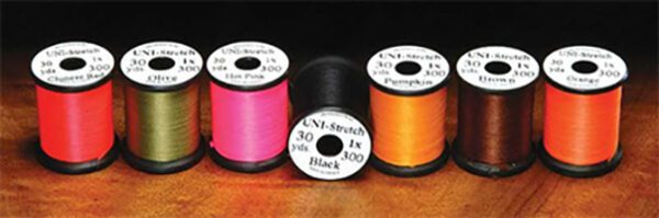 A group of three spools of thread on top of a table.