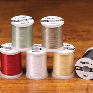 A group of six spools of thread on top of a table.